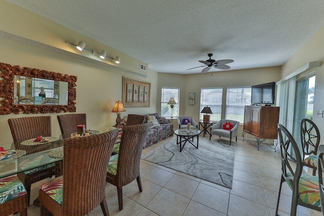 tiled dining room featuring ceiling fan and a textured ceiling