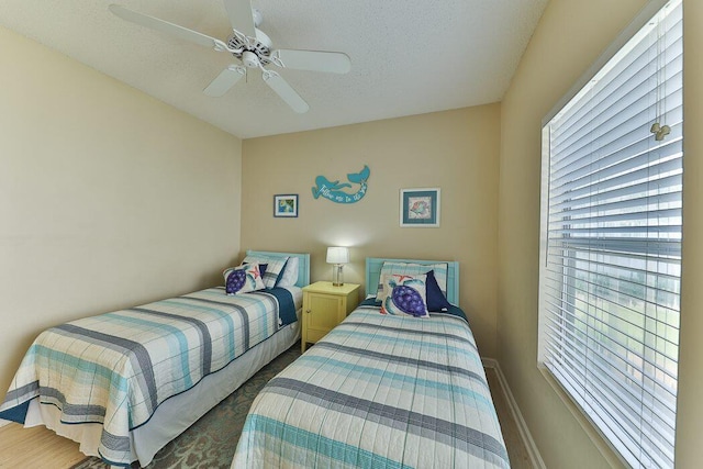 bedroom with ceiling fan and a textured ceiling