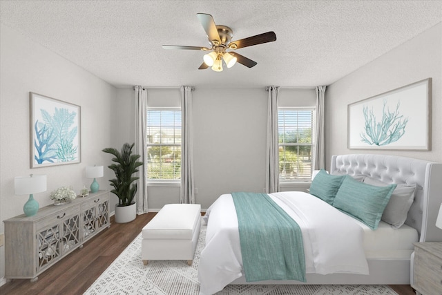 bedroom featuring ceiling fan, a textured ceiling, and dark hardwood / wood-style floors