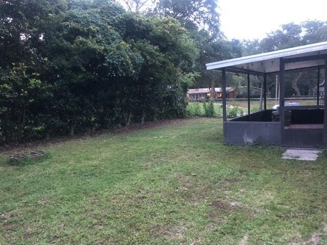 view of yard with a sunroom and a carport