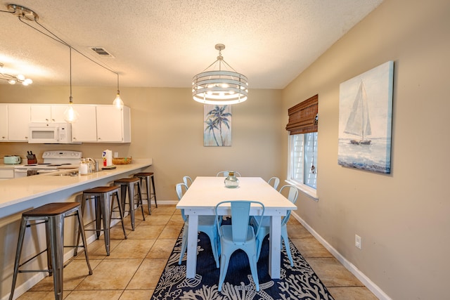 tiled dining area with a textured ceiling