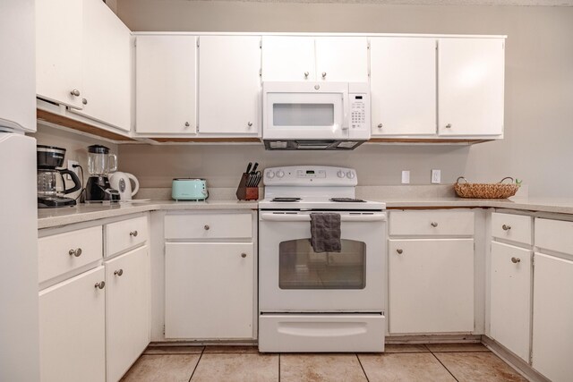 kitchen with white cabinetry, white appliances, and light tile patterned floors