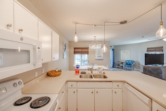 kitchen with white appliances, white cabinets, sink, decorative light fixtures, and a textured ceiling