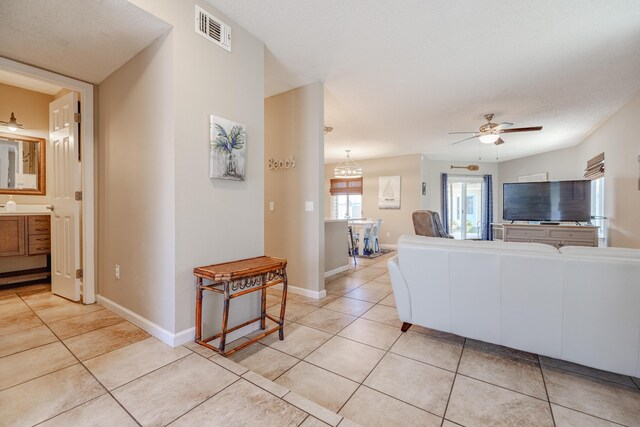 tiled living room featuring a textured ceiling and ceiling fan