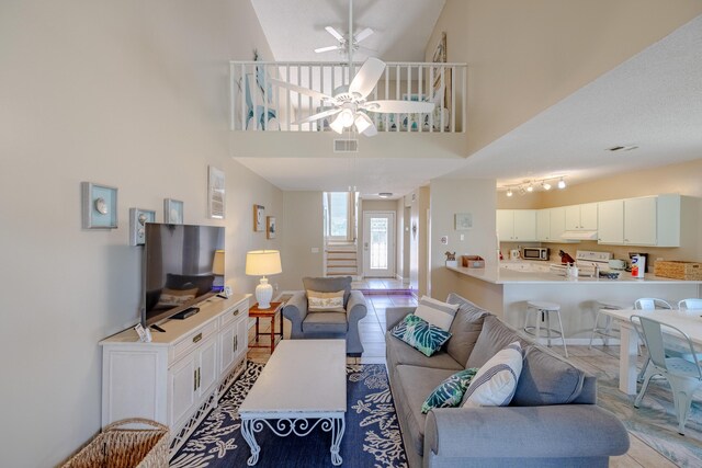 living room featuring high vaulted ceiling, ceiling fan, and light tile patterned floors