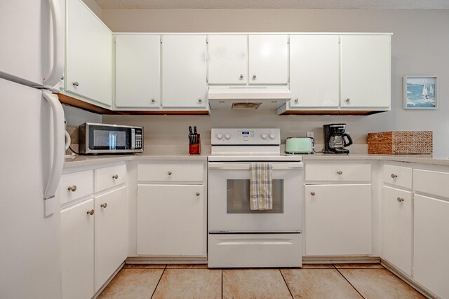 kitchen featuring light tile patterned flooring, custom exhaust hood, white cabinets, and white appliances