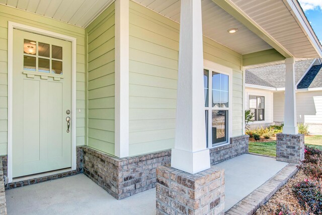 view of exterior entry featuring covered porch