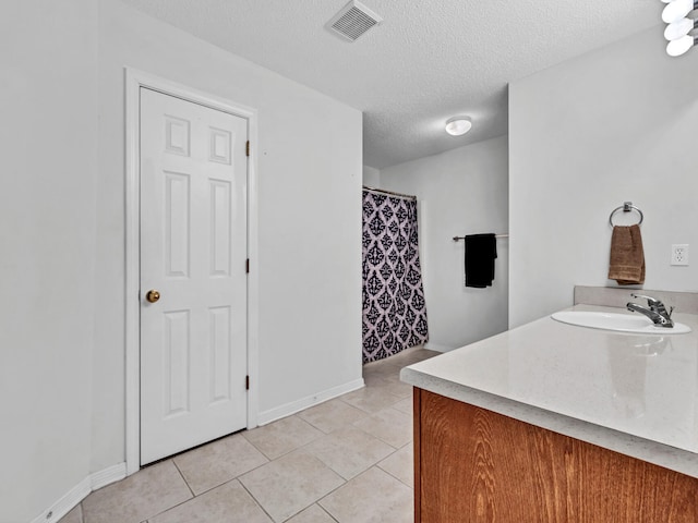 bathroom featuring vanity, a textured ceiling, and tile patterned floors