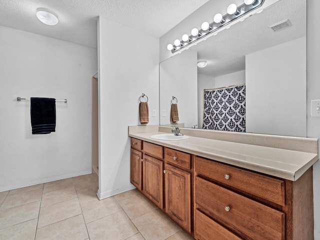 bathroom featuring vanity, a textured ceiling, and tile patterned flooring