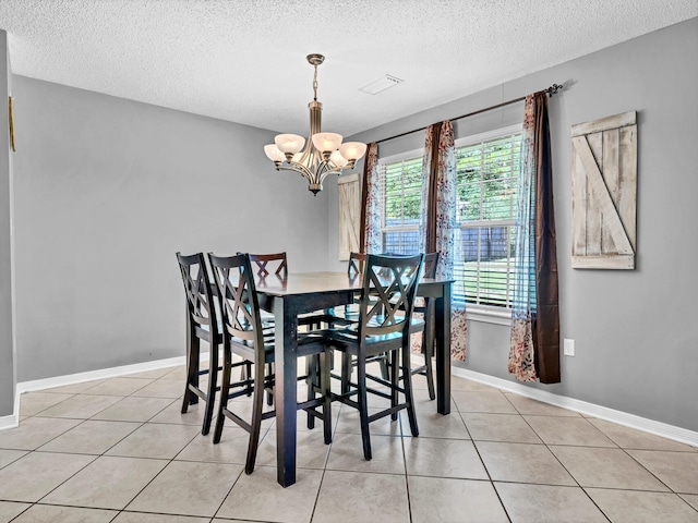 tiled dining area with an inviting chandelier and a textured ceiling