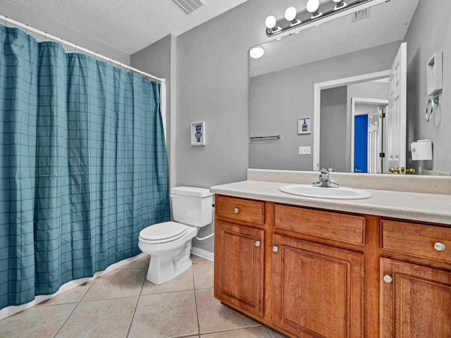 bathroom featuring tile patterned floors, vanity, a textured ceiling, and toilet