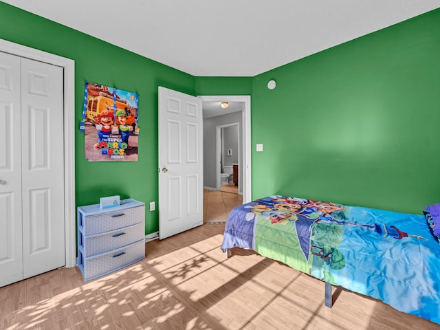 bedroom with light hardwood / wood-style floors and a closet