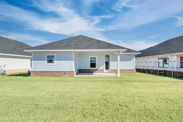 rear view of property featuring a patio area and a lawn