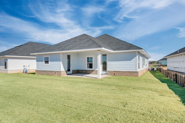 back of house featuring a patio area and a lawn