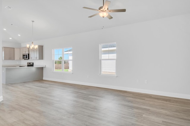 unfurnished living room featuring lofted ceiling, ceiling fan with notable chandelier, and light hardwood / wood-style floors