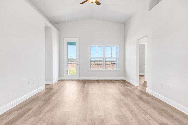 spare room with lofted ceiling, light wood-type flooring, and ceiling fan