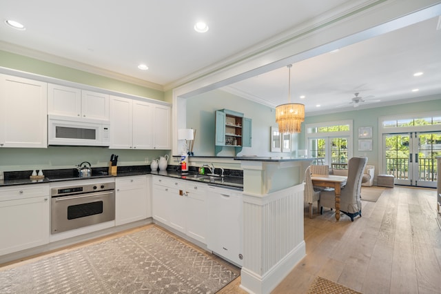 kitchen with white appliances, french doors, kitchen peninsula, light hardwood / wood-style floors, and crown molding