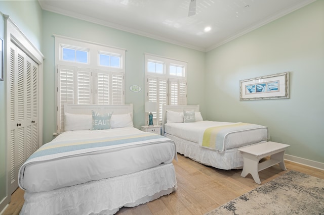 bedroom with crown molding, a closet, light wood-type flooring, and ceiling fan