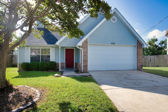 view of front of property with brick siding, fence, a garage, driveway, and a front lawn