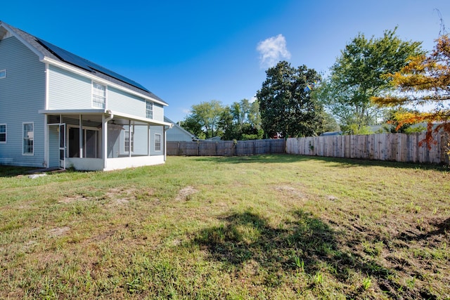 view of yard featuring a fenced backyard and a sunroom