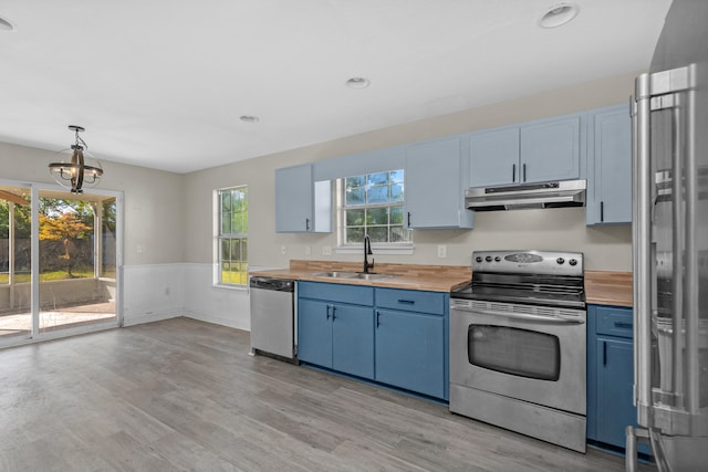 kitchen with light wood-type flooring, stainless steel appliances, blue cabinetry, and sink