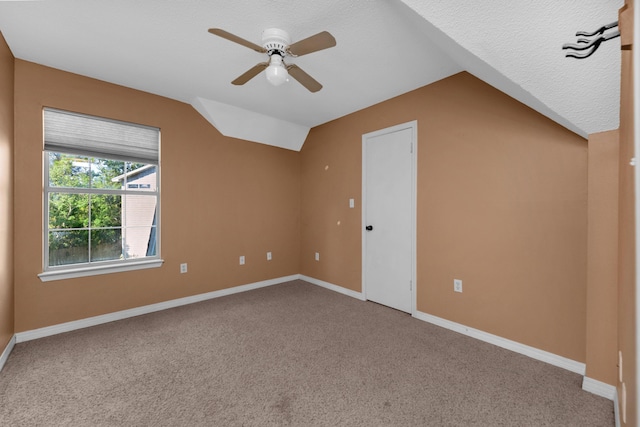 additional living space featuring a ceiling fan, lofted ceiling, light carpet, and baseboards