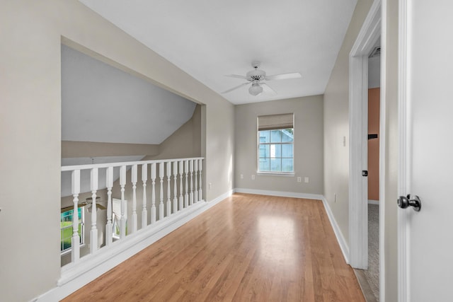 interior space with a ceiling fan, baseboards, and wood finished floors