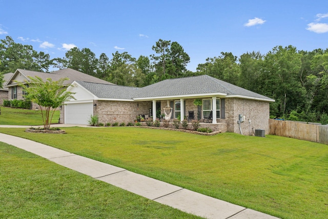 ranch-style house featuring a front yard, a garage, and central air condition unit