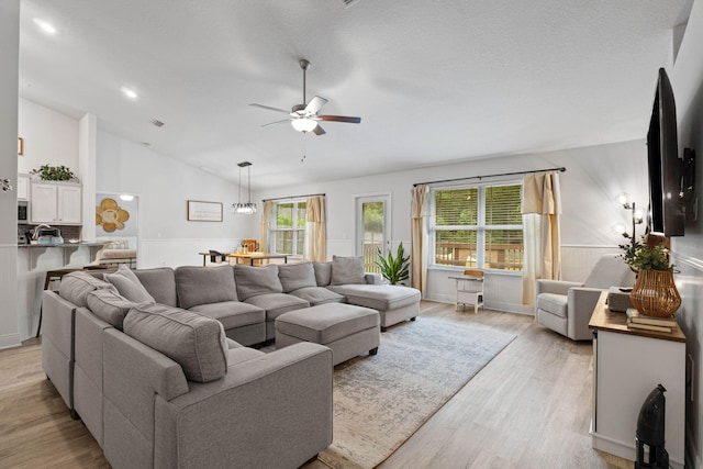 living room with high vaulted ceiling, ceiling fan, and light hardwood / wood-style floors