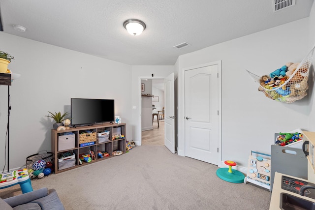 game room featuring light carpet and a textured ceiling