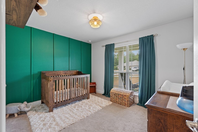 bedroom with carpet and a nursery area