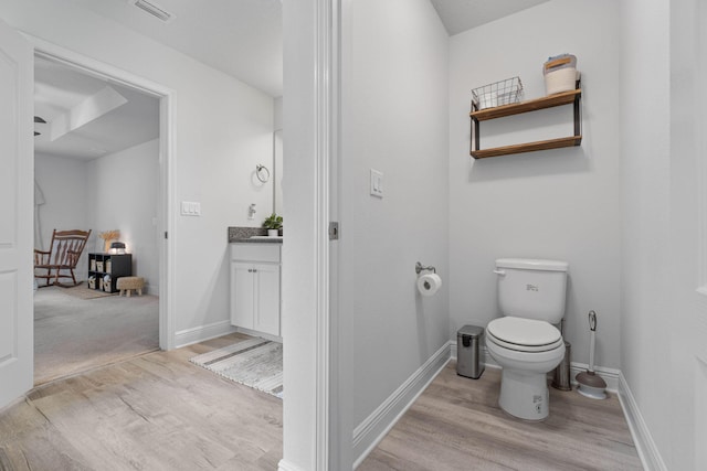 bathroom featuring vanity, toilet, and hardwood / wood-style floors