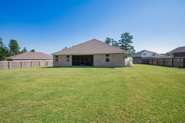 6537 Torrey Pnes, Laurel Hill, FL 32567 - rear view of house featuring a lawn, brick siding, and a fenced backyard