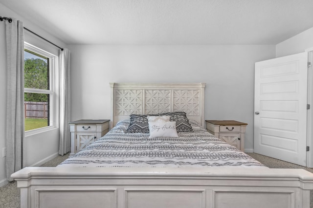 carpeted bedroom with multiple windows and a textured ceiling