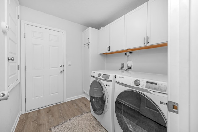 laundry room featuring separate washer and dryer, light hardwood / wood-style flooring, and cabinets