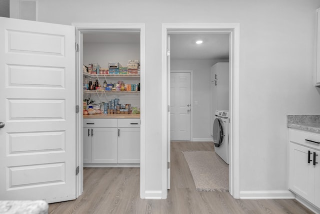 washroom featuring washer / clothes dryer and light hardwood / wood-style floors