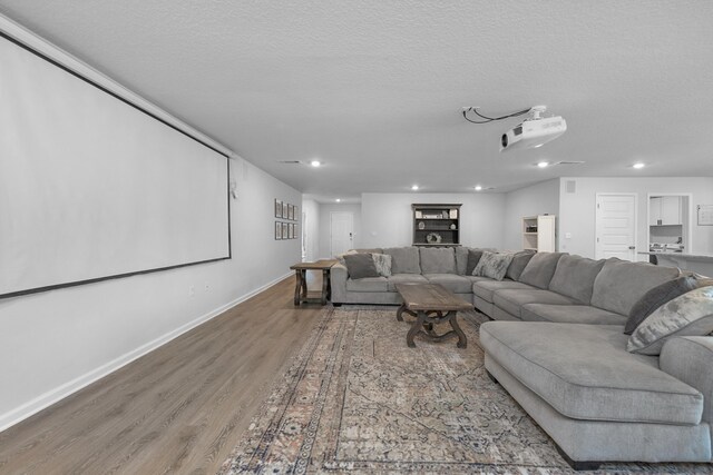 cinema room featuring a textured ceiling and hardwood / wood-style floors