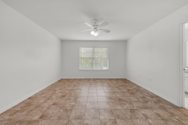 tiled empty room featuring ceiling fan