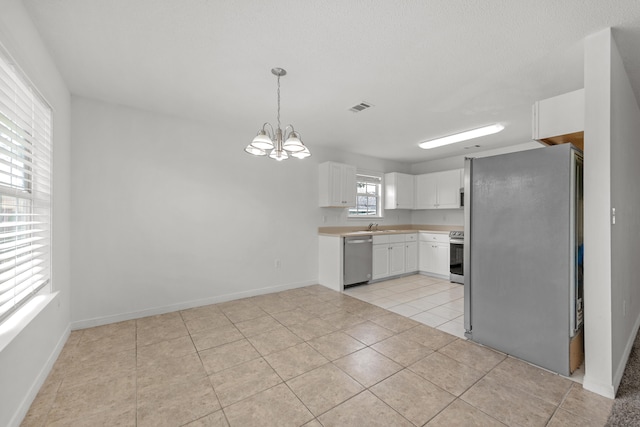 kitchen with a notable chandelier, decorative light fixtures, light tile patterned flooring, white cabinetry, and stainless steel appliances