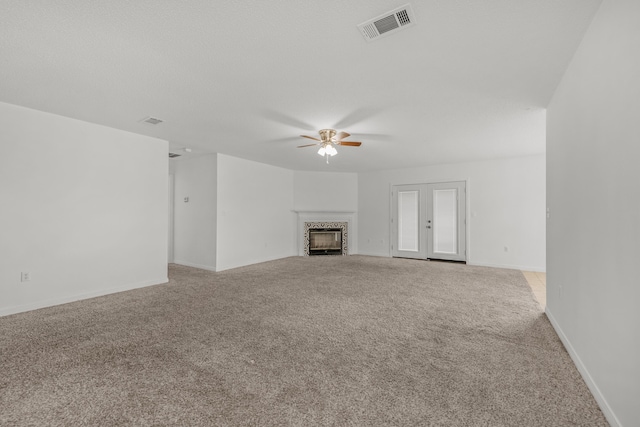 unfurnished living room with light colored carpet and ceiling fan