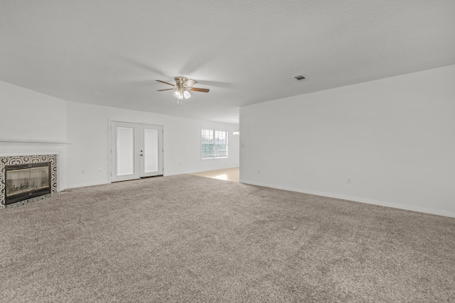 unfurnished living room featuring carpet and ceiling fan