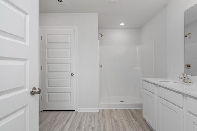 bathroom with vanity, hardwood / wood-style flooring, and walk in shower