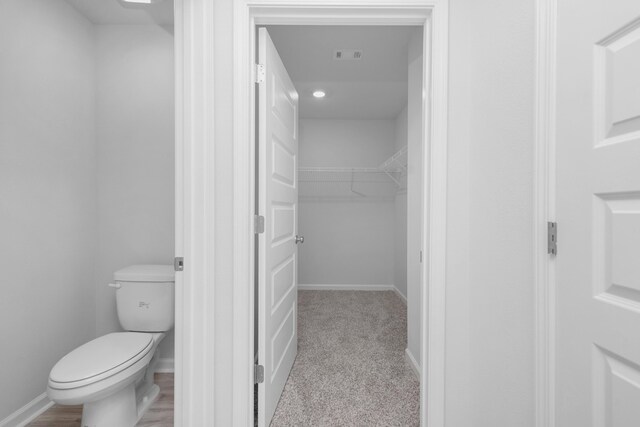 bathroom featuring toilet and wood-type flooring