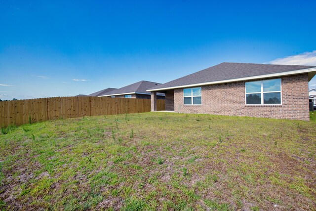 rear view of house featuring a lawn