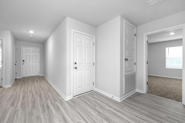 corridor featuring light colored carpet