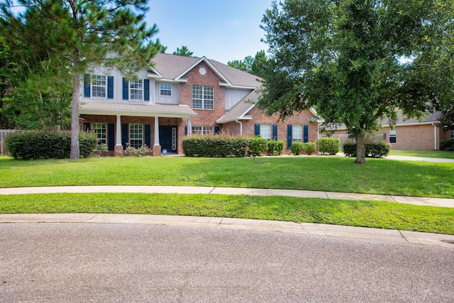 view of front of home with brick siding, roof with shingles, and a front yard