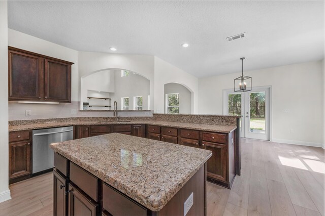 kitchen with sink, dishwasher, light wood-type flooring, and a center island