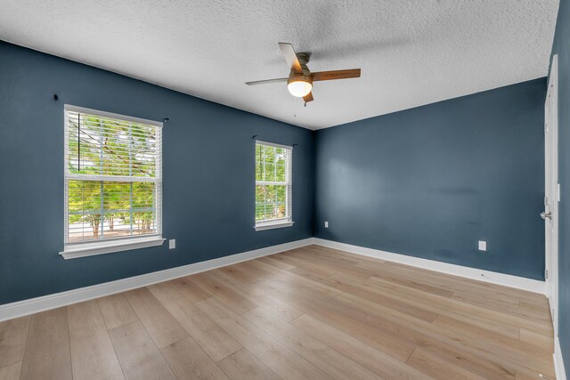 unfurnished room with a textured ceiling, ceiling fan, and light wood-type flooring