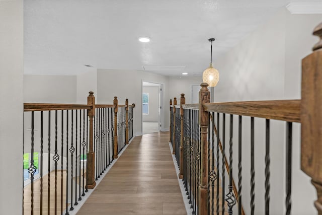 hall featuring light wood finished floors, an upstairs landing, and baseboards