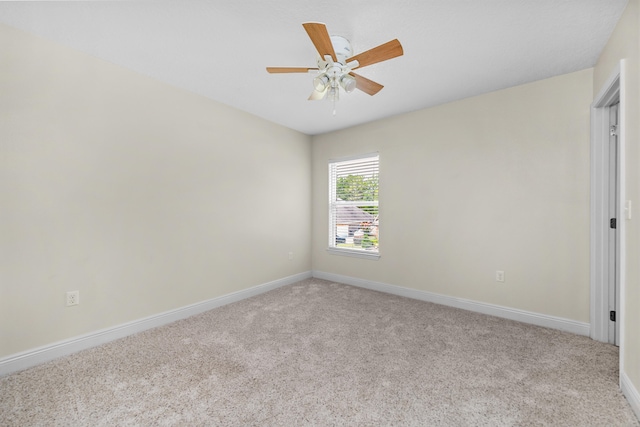 carpeted spare room featuring ceiling fan